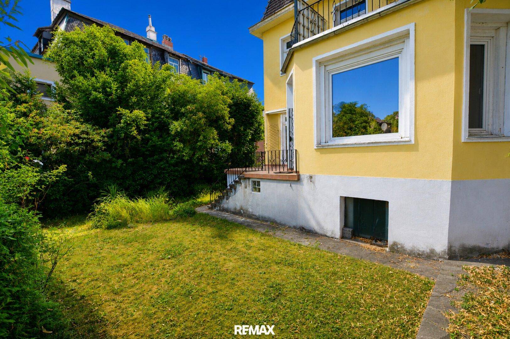 Kleiner Gartenbereich neben der Villa mit Rasenfläche und direktem Zugang zum Gebäude.