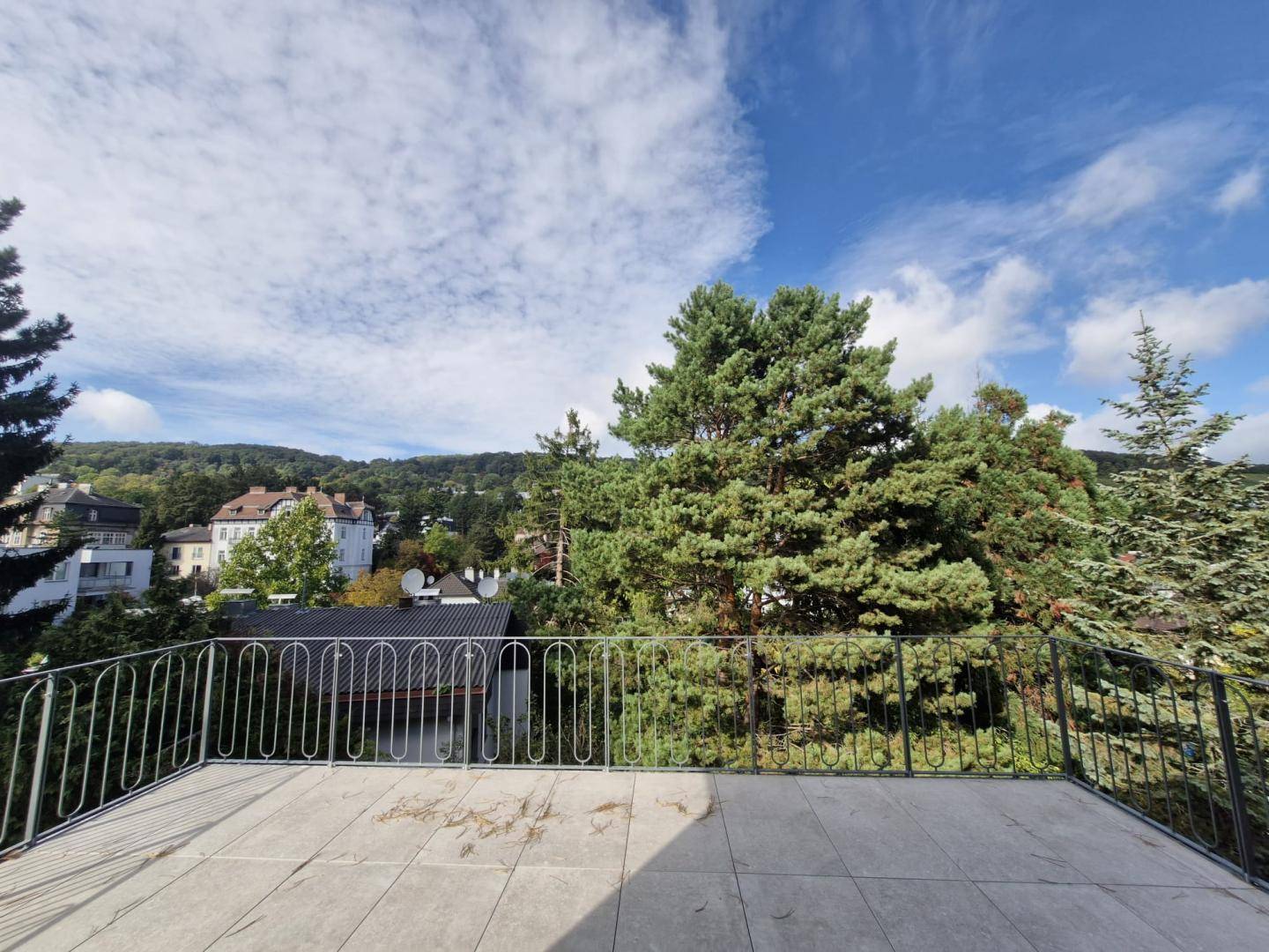 Weitläufige Dachterrasse mit Panoramablick über die grüne Umgebung und die Stadt.