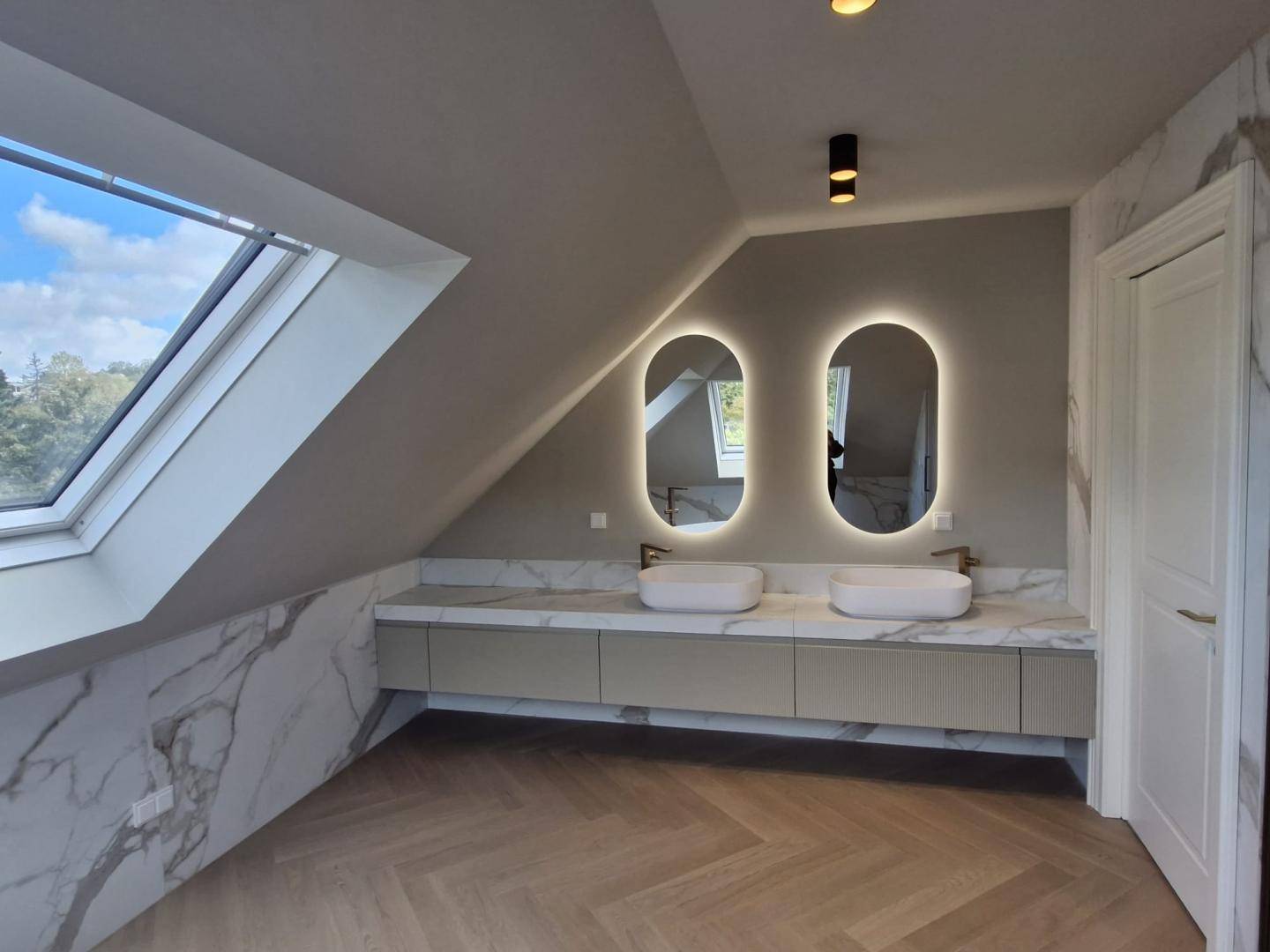 Modernes Badezimmer im Dachgeschoss mit Doppelwaschbecken, Marmoroberflächen und Dachfenster.
