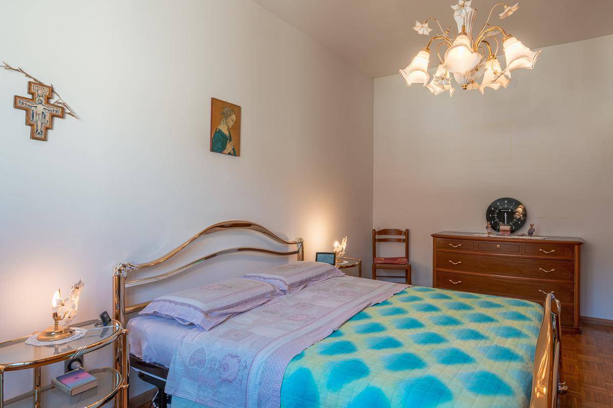 Gemütliches Schlafzimmer mit klassischem Bettgestell und Holzkommode.
