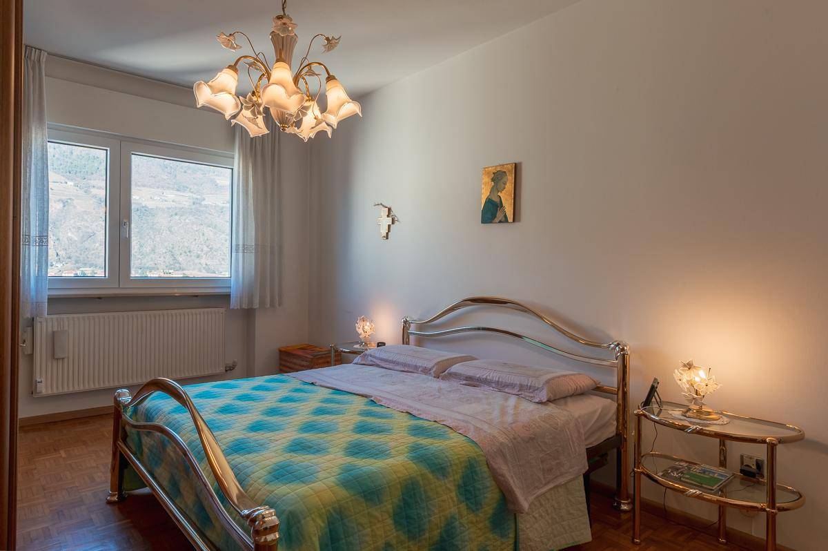 Schlafzimmer mit Doppelbett, Parkettboden und Blick auf die Berge.