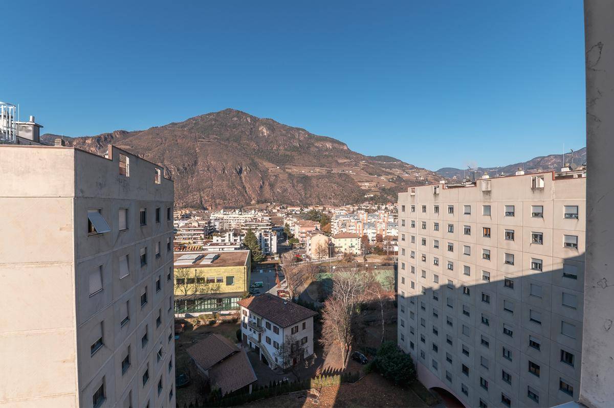 Panoramablick vom Balkon auf die Stadt und die beeindruckende Berglandschaft.