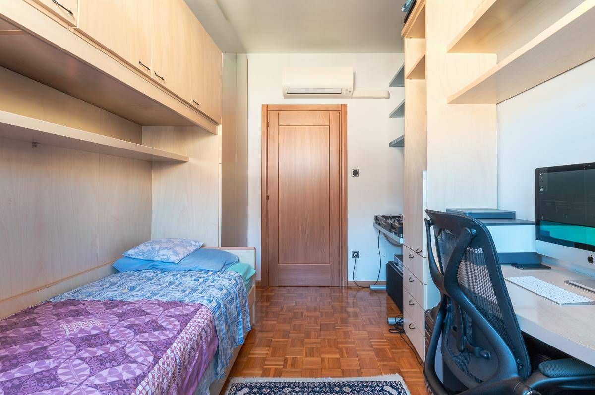 Funktionales Zimmer mit Bett, Schreibtisch und Klimaanlage.