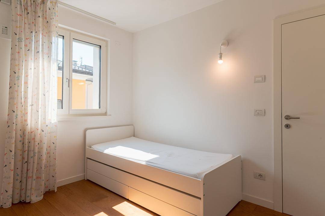 Kinderzimmer oder Gästezimmer mit Einzelbett, Holzboden und hellem Fenster.