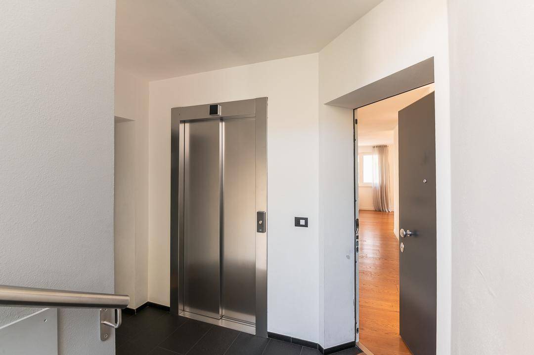 Eingangsbereich mit modernem Aufzug und Zugang zu einer Wohnung.