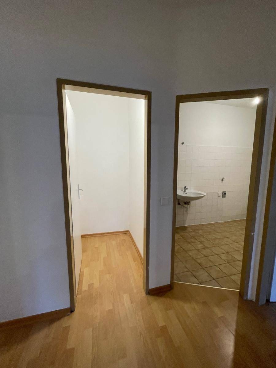 Flur mit Zugang zu einem Abstellraum und einem Badezimmer.