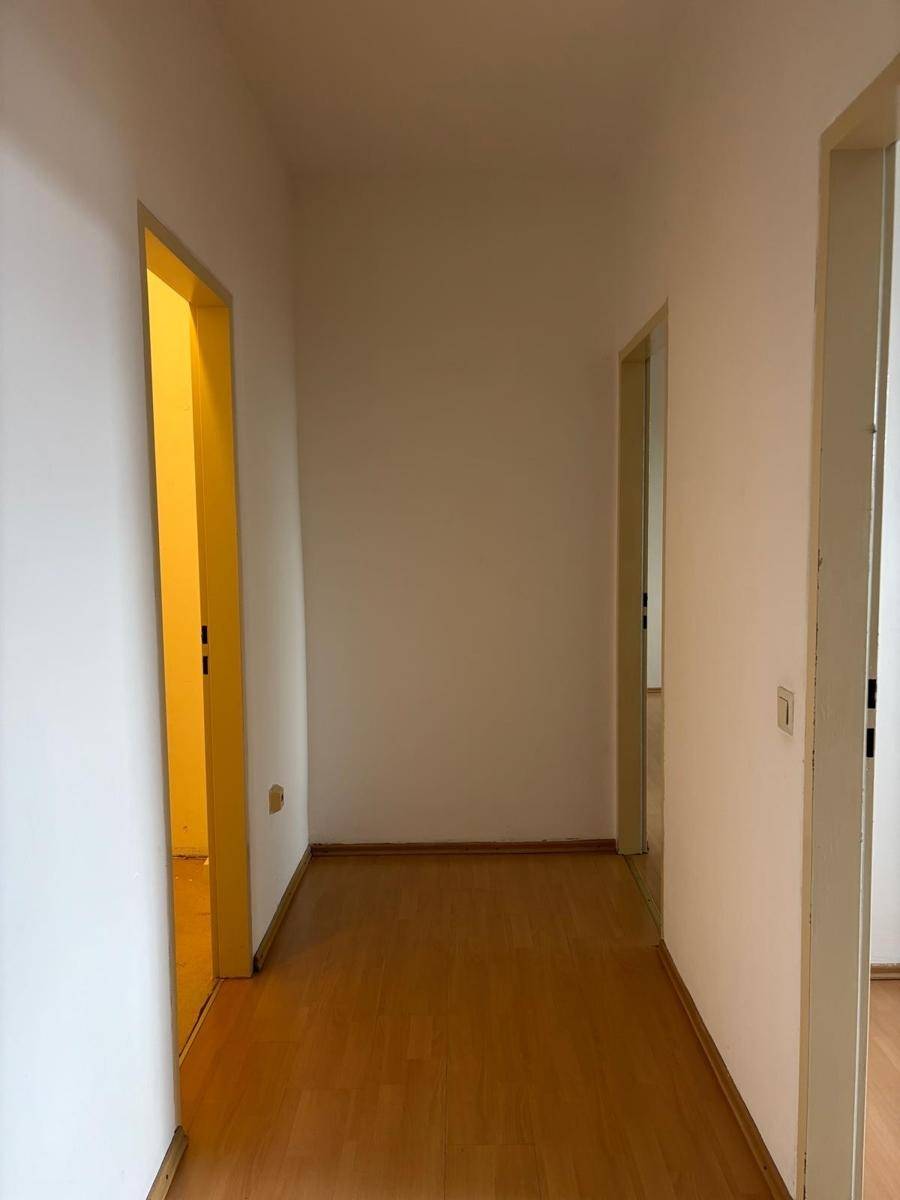 Heller Flur mit Laminatboden und Zugang zu mehreren Zimmern, bietet eine praktische Raumaufteilung.