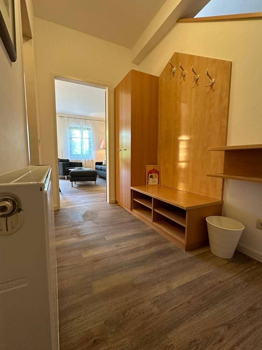 Eingangsbereich mit Garderobe, Schuhregal und Blick in den offenen Wohnbereich.