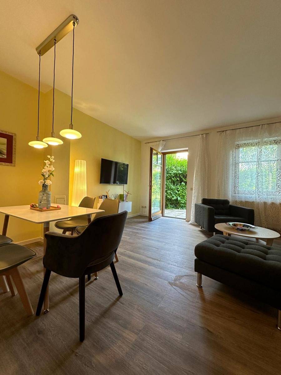 Geräumiger Wohn-Essbereich mit Laminatboden, direktem Zugang zum Garten und moderner Einrichtung.
