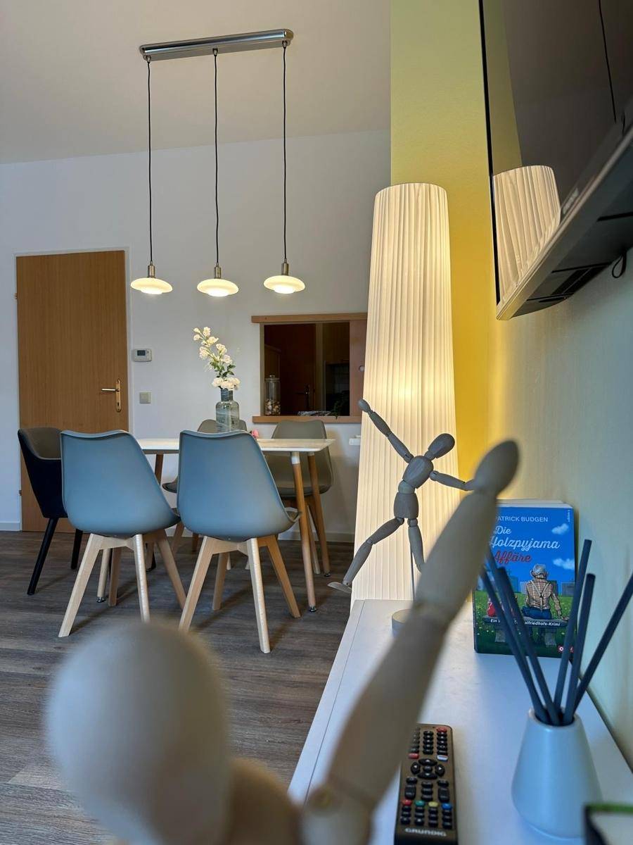 Detailansicht des Essbereichs mit Pendelleuchten und einer dekorativen Stehlampe im modernen Stil.
