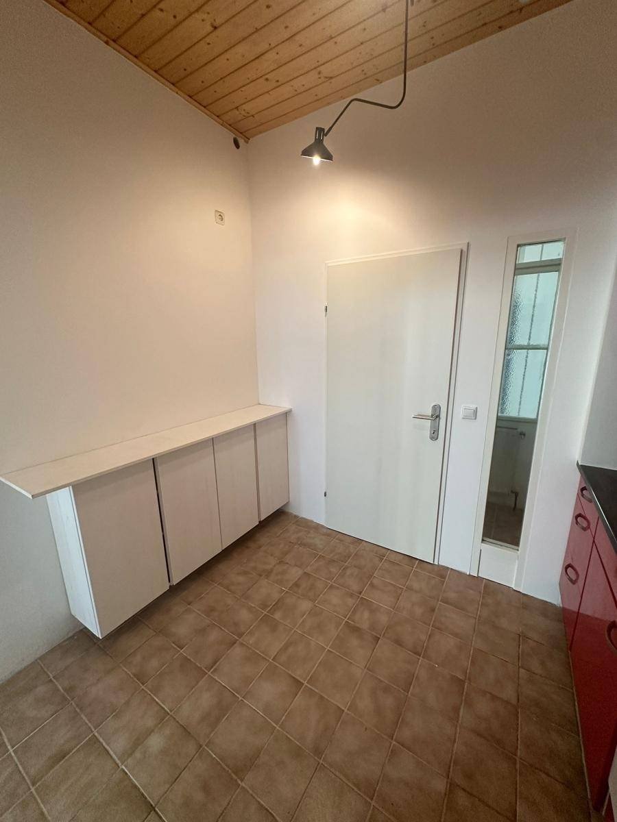 Küchenbereich mit zusätzlichen weißen Unterschränken und Fliesenboden.