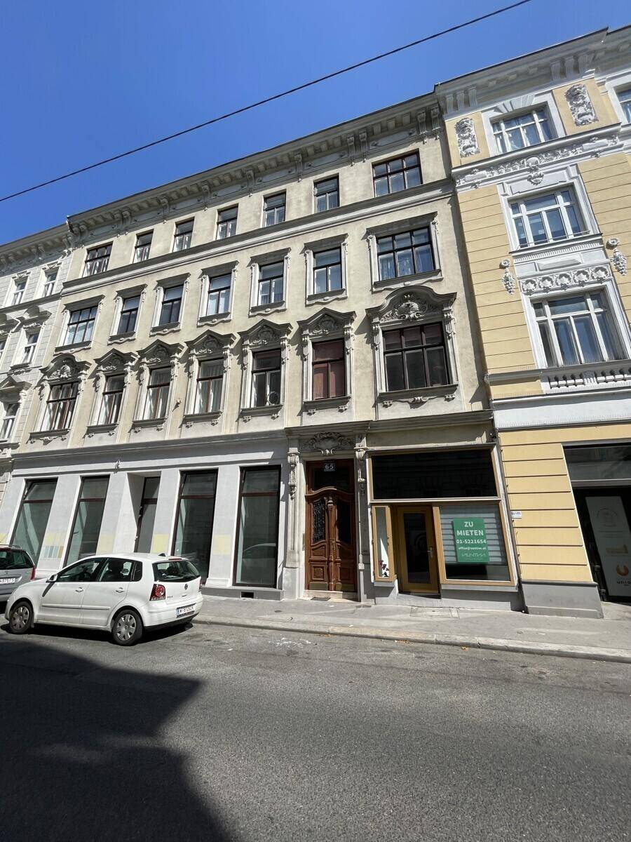 Historische Gebäude entlang einer Straße mit geparkten Autos und einem 