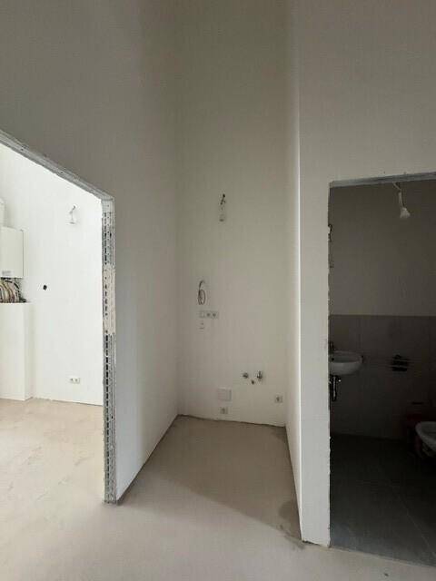 Ecke des Ladenlokals mit Zugang zu einem Sanitärbereich und einem möglichen Küchenanschluss.