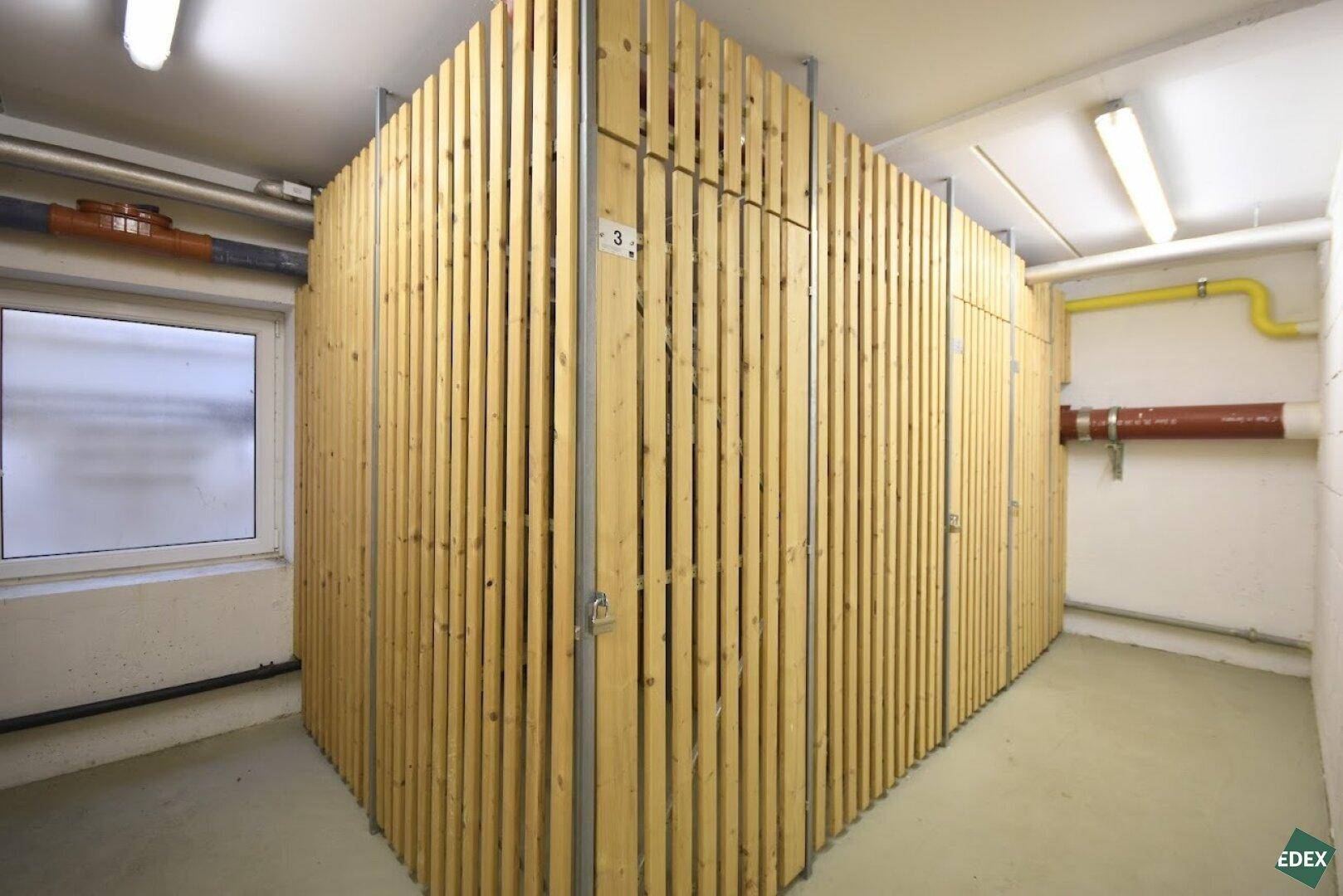 Kellerabteile mit Holzlattenwänden bieten zusätzlichen Stauraum für Bewohner.