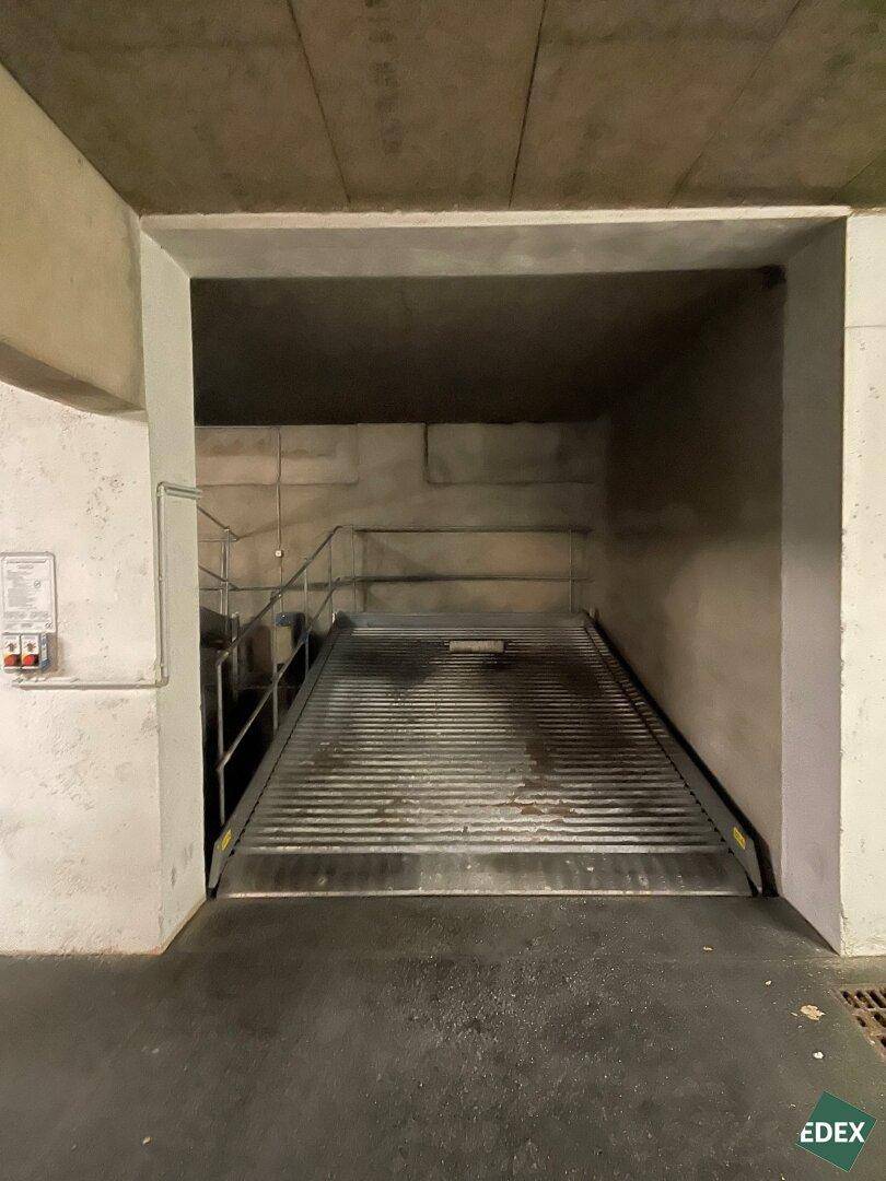Leere Parkplattform in der Tiefgarage, bereit zur Aufnahme eines Fahrzeugs, umgeben von Betonwänden.