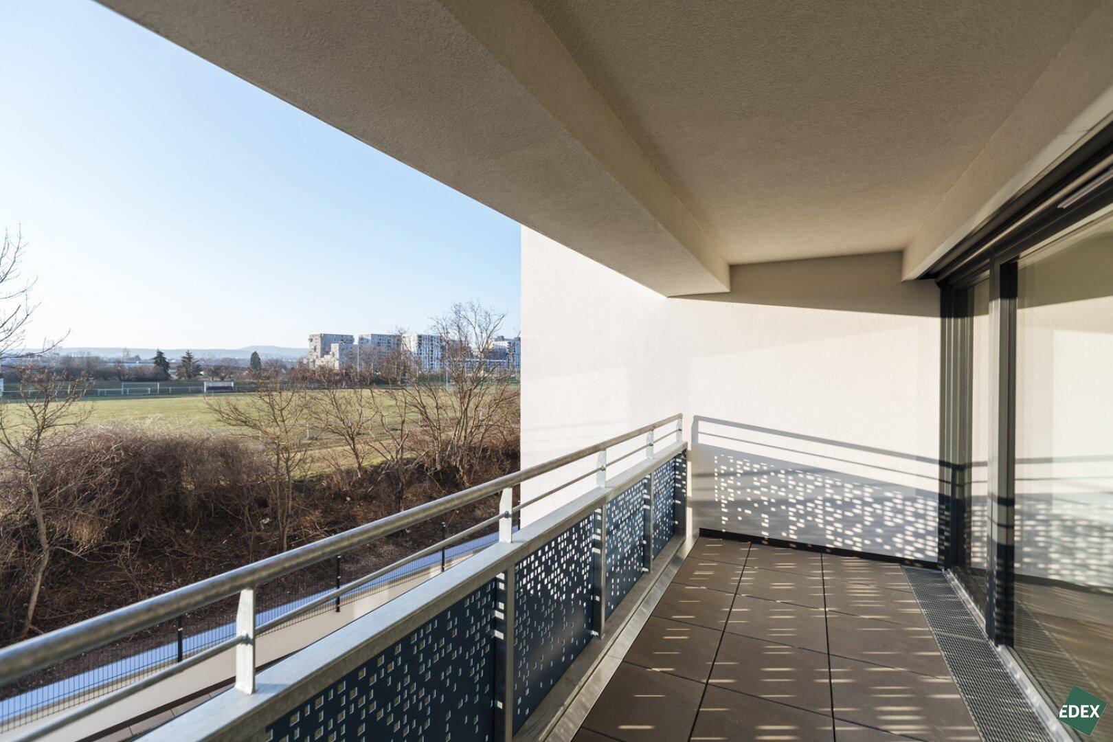 Balkon mit Blick auf die Umgebung und kahle Bäume im Winter.