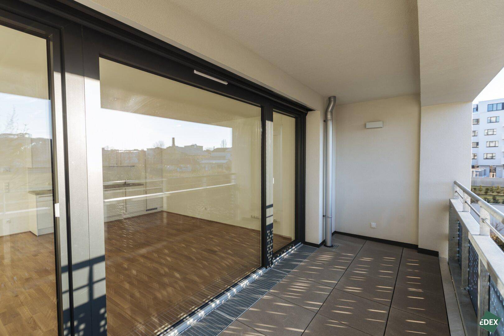 Balkon mit Blick auf die Stadt und angrenzende Gebäude.
