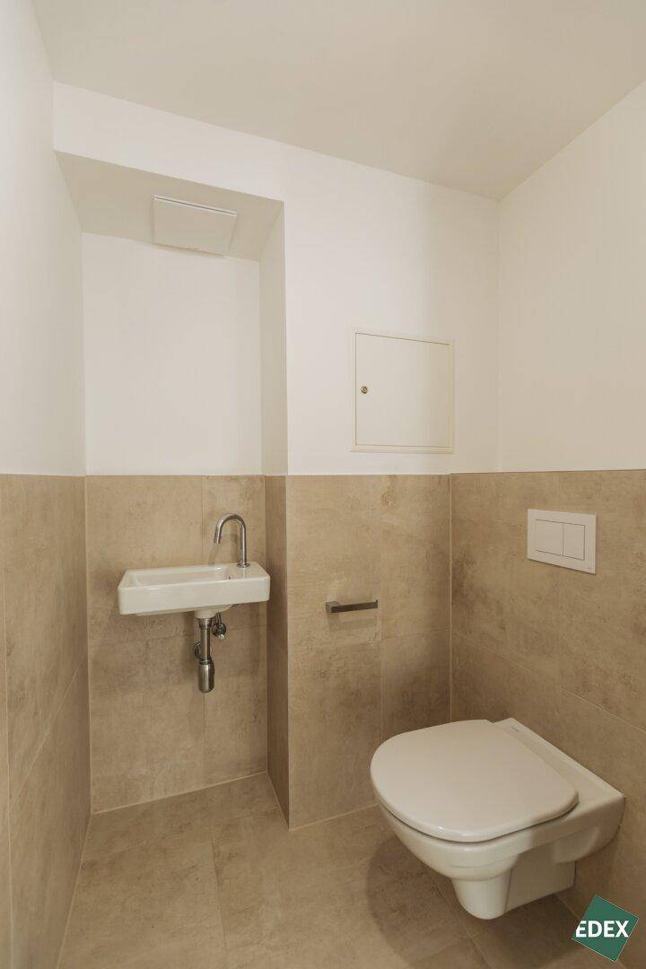 Modernes Gäste-WC mit Wand-WC und kleinem Waschbecken.
