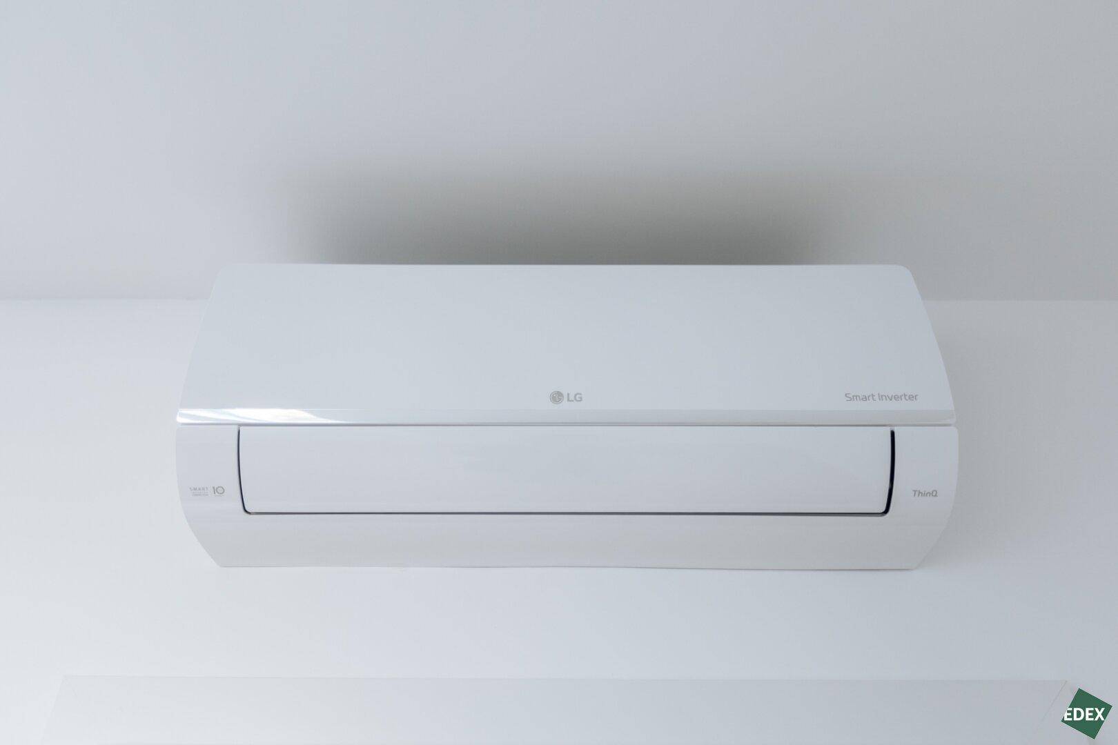 Nahaufnahme einer LG Smart Inverter Klimaanlage, die an einer weißen Wand montiert ist.