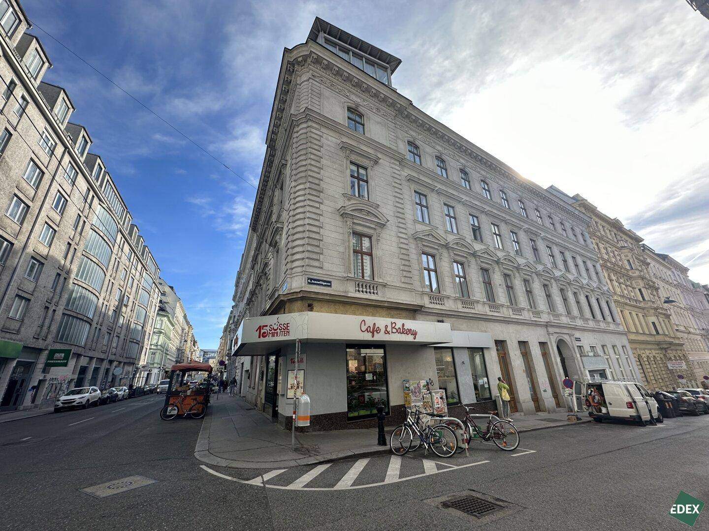 Historisches Gebäude an einer Straßenecke mit Geschäften im Erdgeschoss.