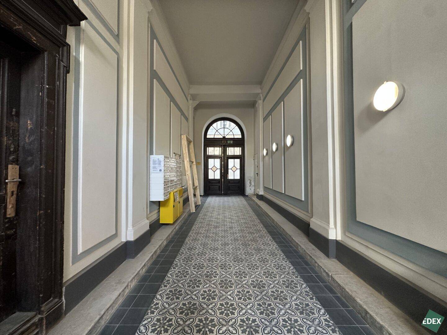 Elegante Eingangshalle mit gemustertem Fliesenboden und hohen Decken.