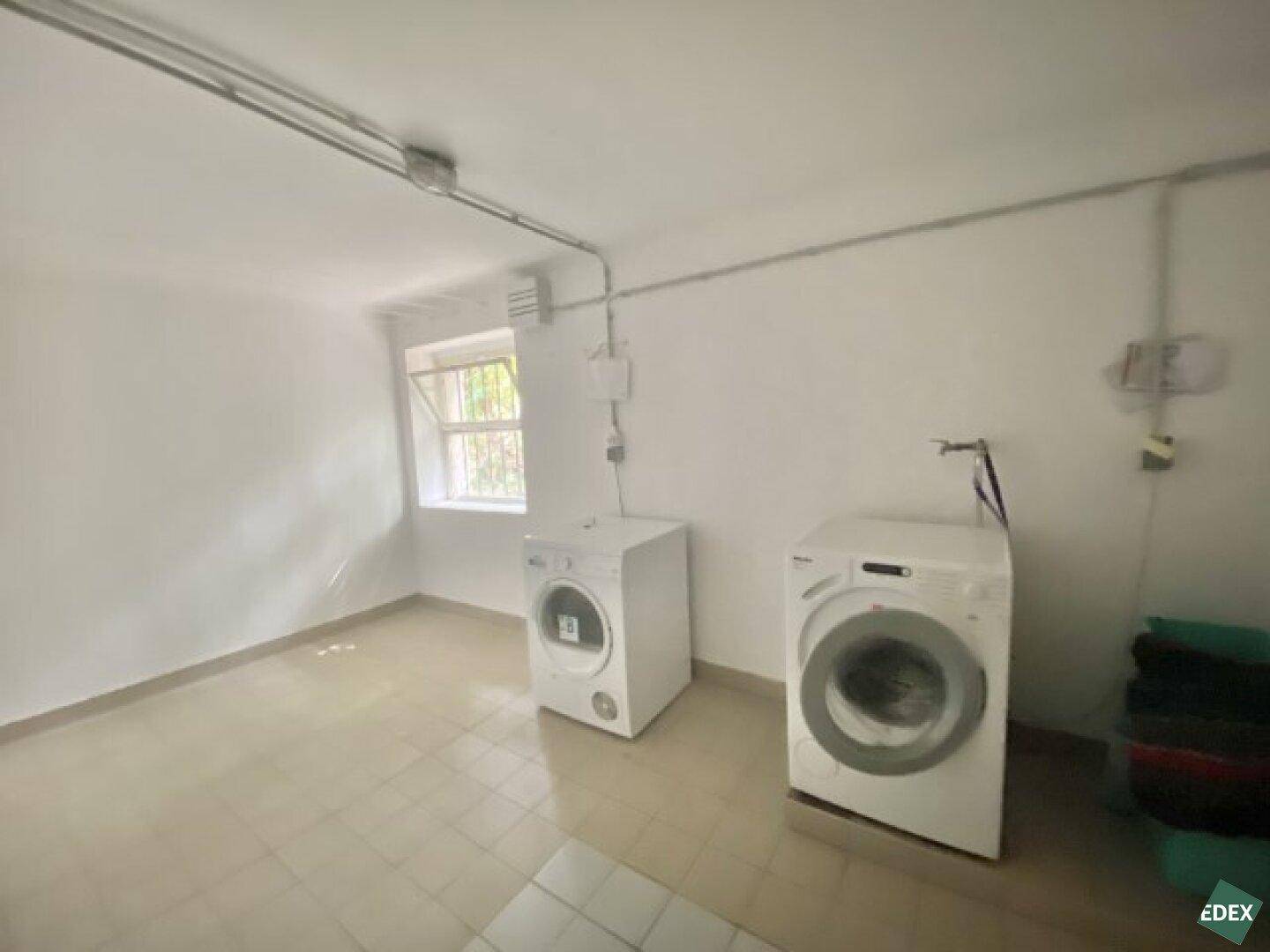 Geräumiger Hauswirtschaftsraum mit Waschmaschinen und einem Fenster für Belüftung.