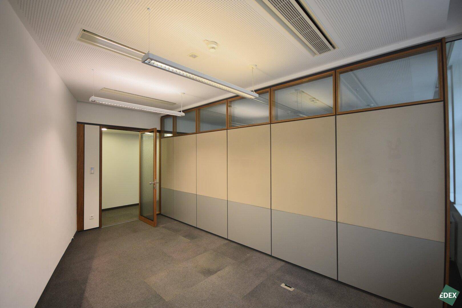 Büro mit Teppichboden und Trennwänden, die eine flexible Raumaufteilung ermöglichen, ideal für Einzelbüros.