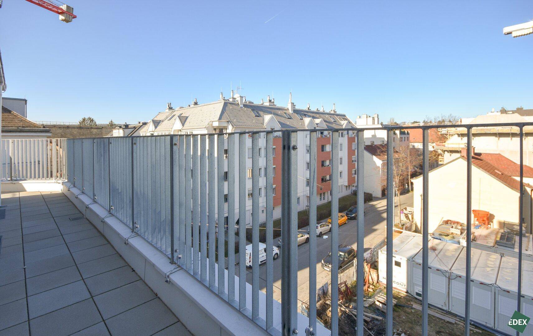 Geräumige Terrasse mit Fliesenboden und weitem Blick über die Dächer der Stadt.
