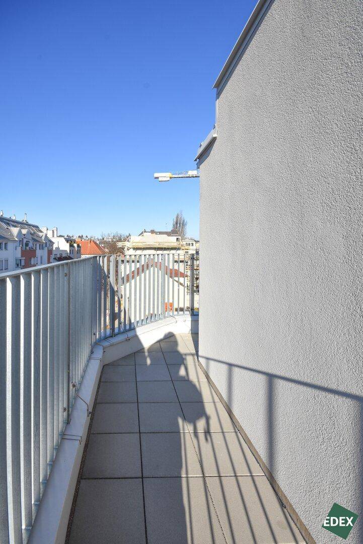 Schmaler Balkon mit Fliesenboden und Blick auf die umliegenden Gebäude der Stadt.