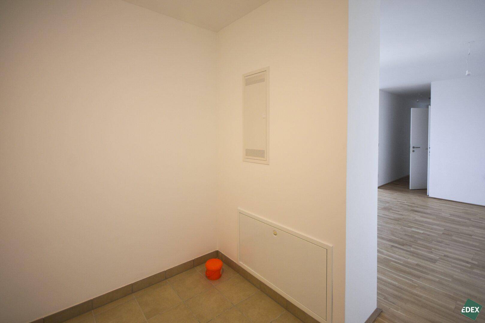 Eingangsbereich mit Fliesenboden und Zugang zu weiteren Räumen, schlicht und funktional.
