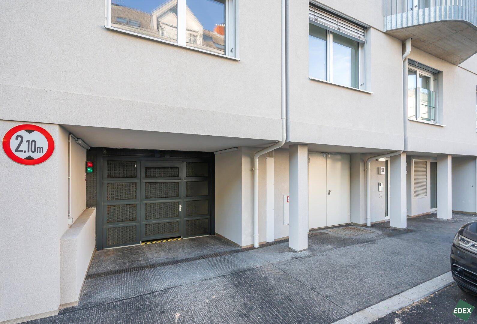 Eingang zur Tiefgarage eines modernen Wohngebäudes mit Höhenbegrenzung.