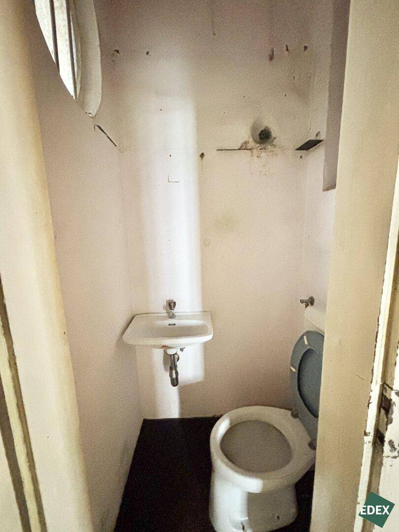 Kleines WC mit Waschbecken und Toilette, in einfachem, funktionalem Zustand.