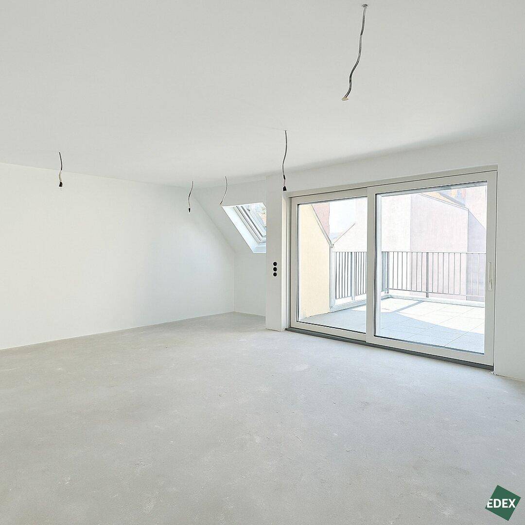 Heller, unmöblierter Raum mit Zugang zu einer Terrasse und einem zusätzlichen Dachfenster.