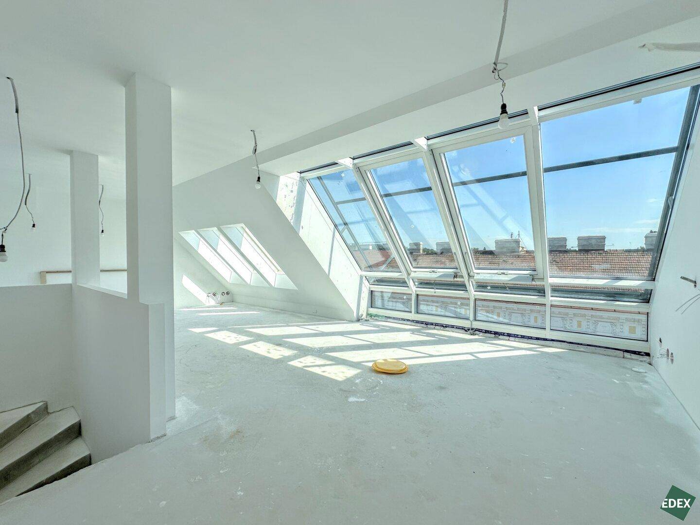 Großer, lichtdurchfluteter Rohbau im Dachgeschoss mit beeindruckenden Dachfenstern und weitem Blick.