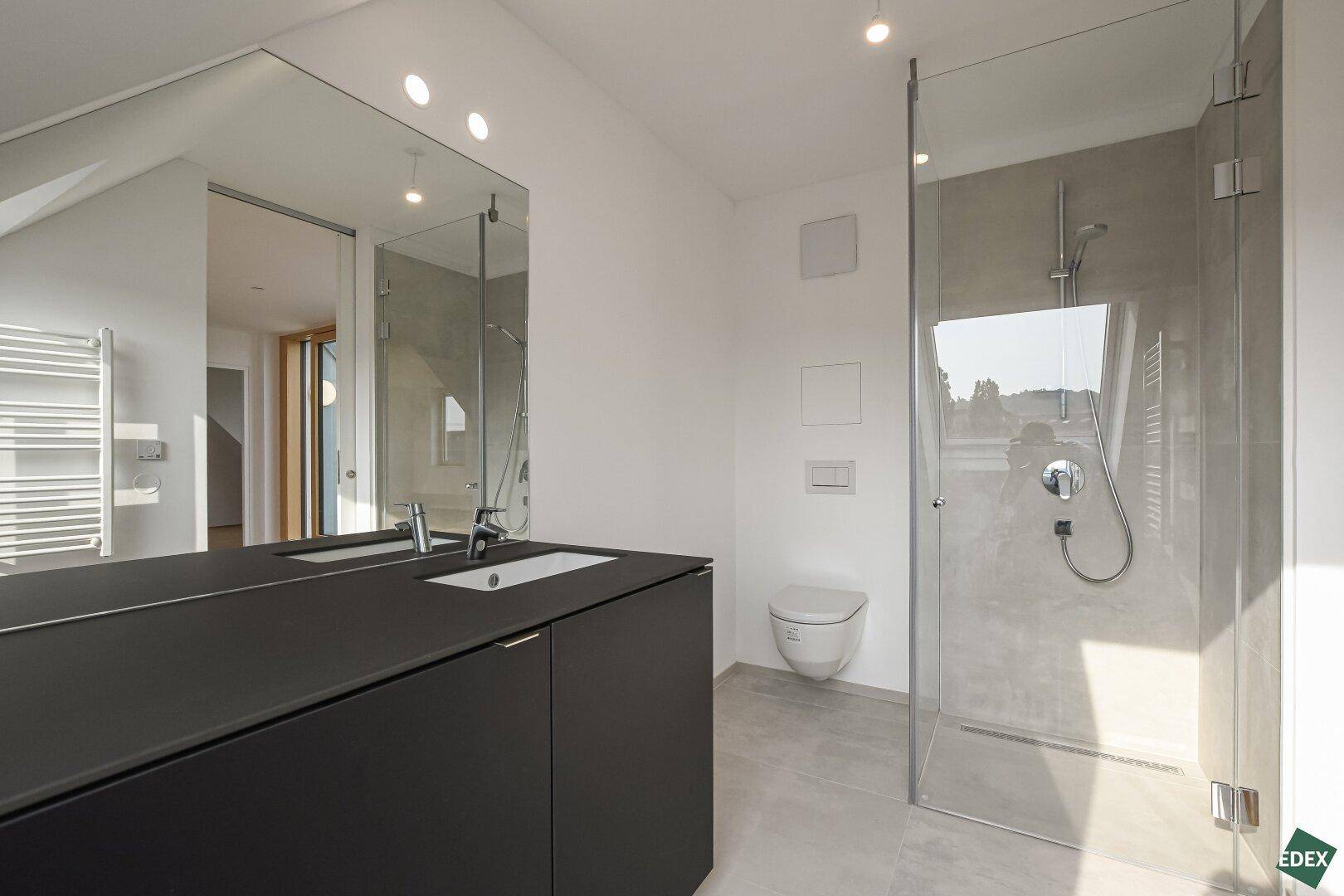 Elegantes Badezimmer mit begehbarer Dusche, modernem Waschtisch und großem Spiegel.