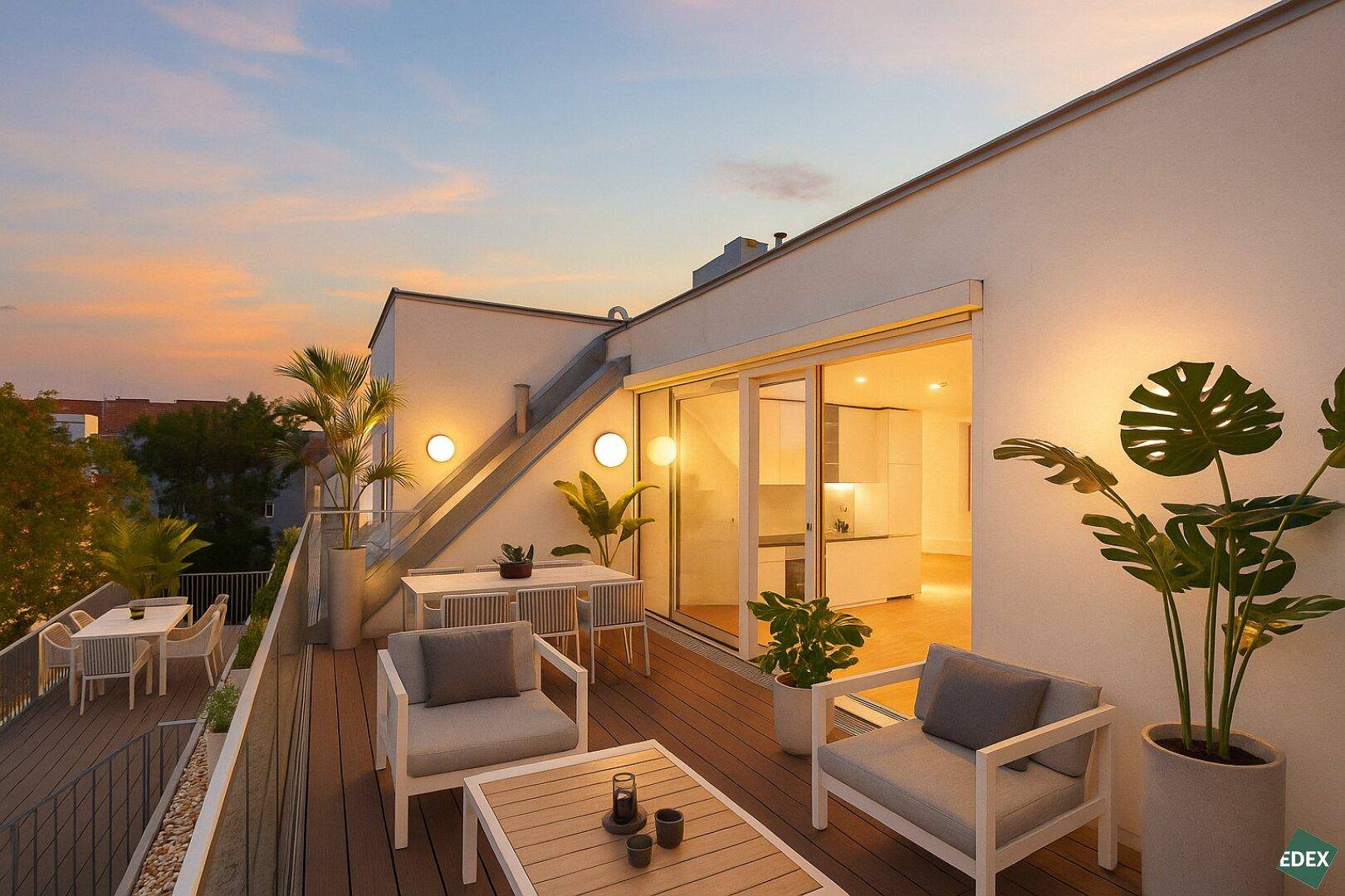 Stimmungsvolle Dachterrasse bei Sonnenuntergang mit bequemen Möbeln und exotischen Pflanzen.