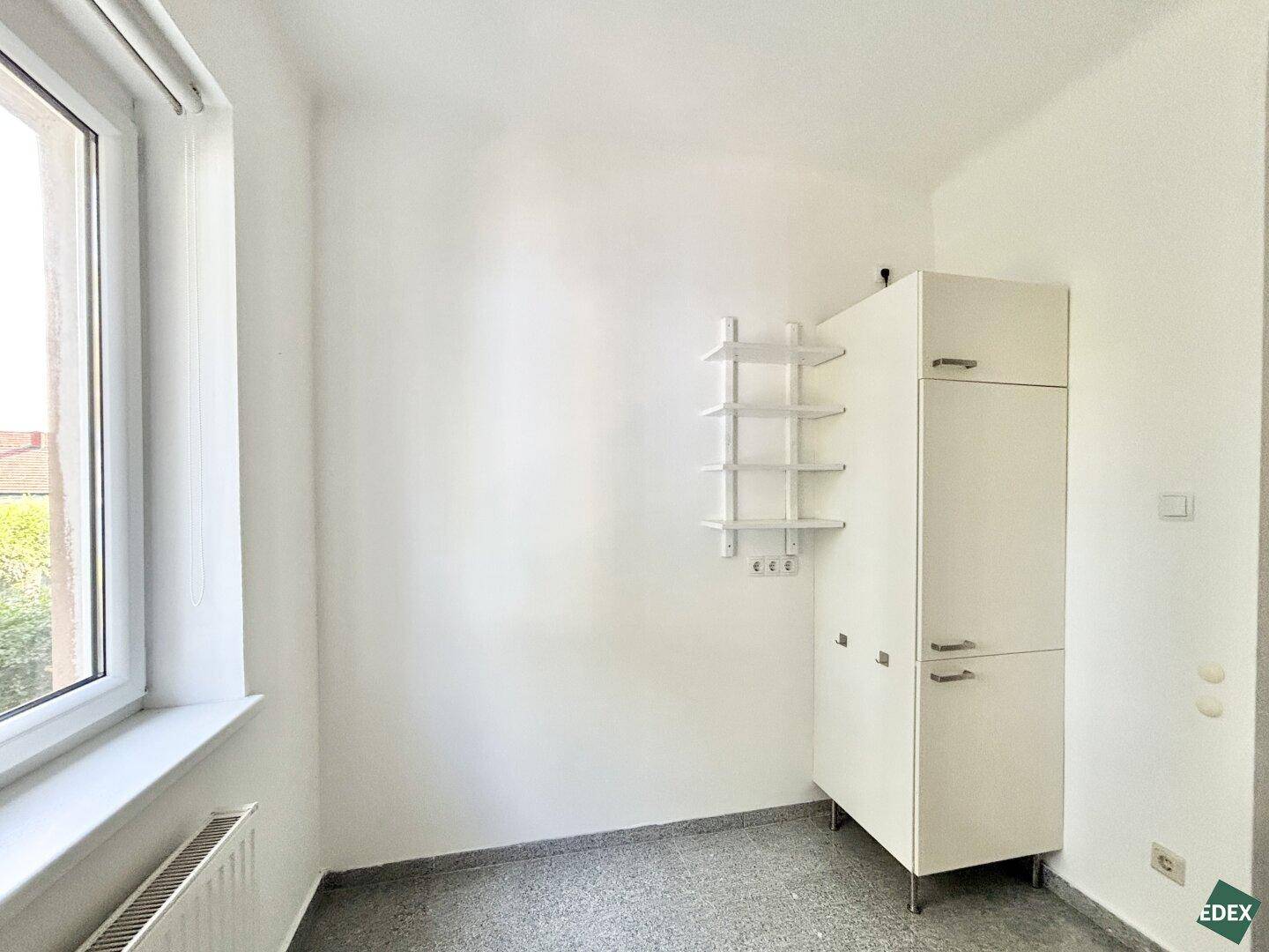 Heller Raum mit weißem Schrank und Regal, ideal als Erweiterung der Küchenzeile oder Abstellraum.