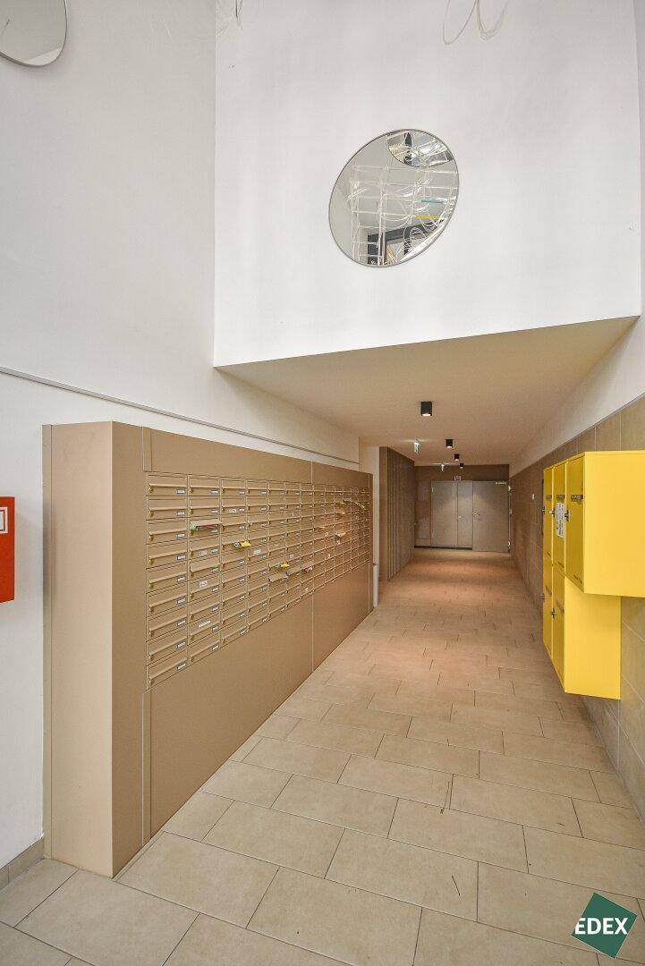 Geräumiger Eingangsbereich mit modernen Briefkästen und heller Beleuchtung im Neubau.