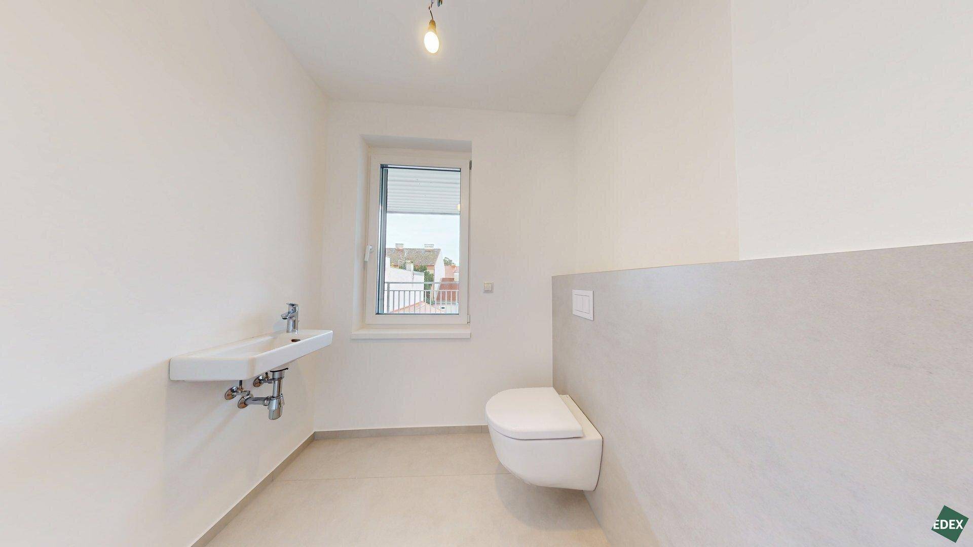 Helles Gäste-WC mit Fenster, wandhängendem WC und modernem Waschbecken.