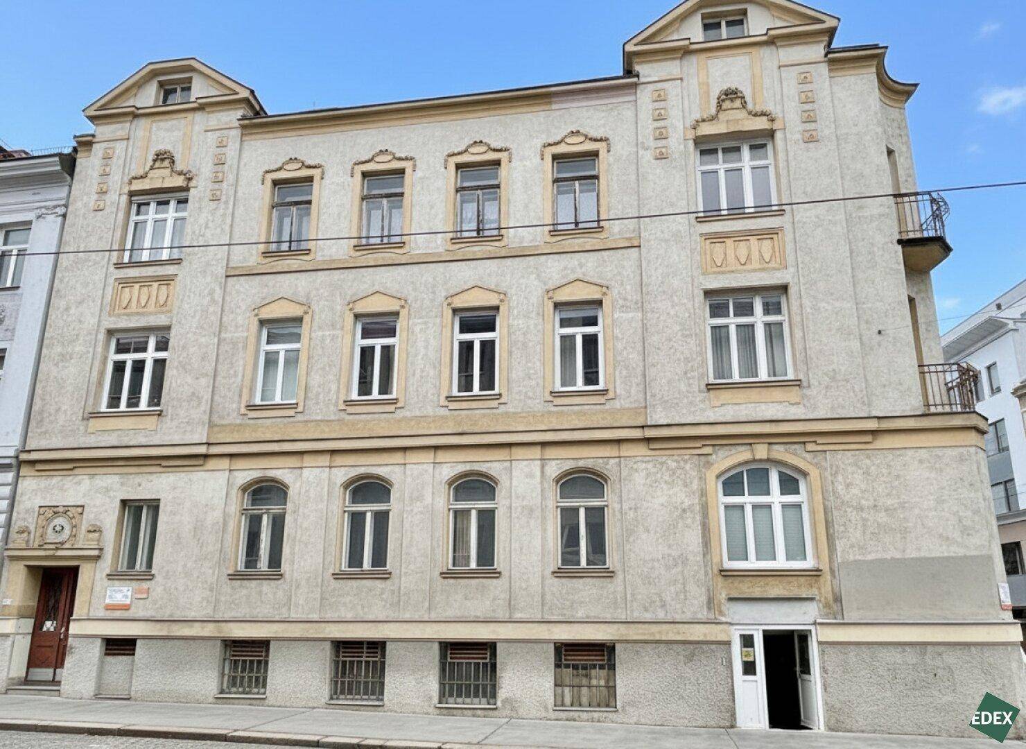 Historisches Mehrfamilienhaus mit klassischer Fassade und Balkonen.