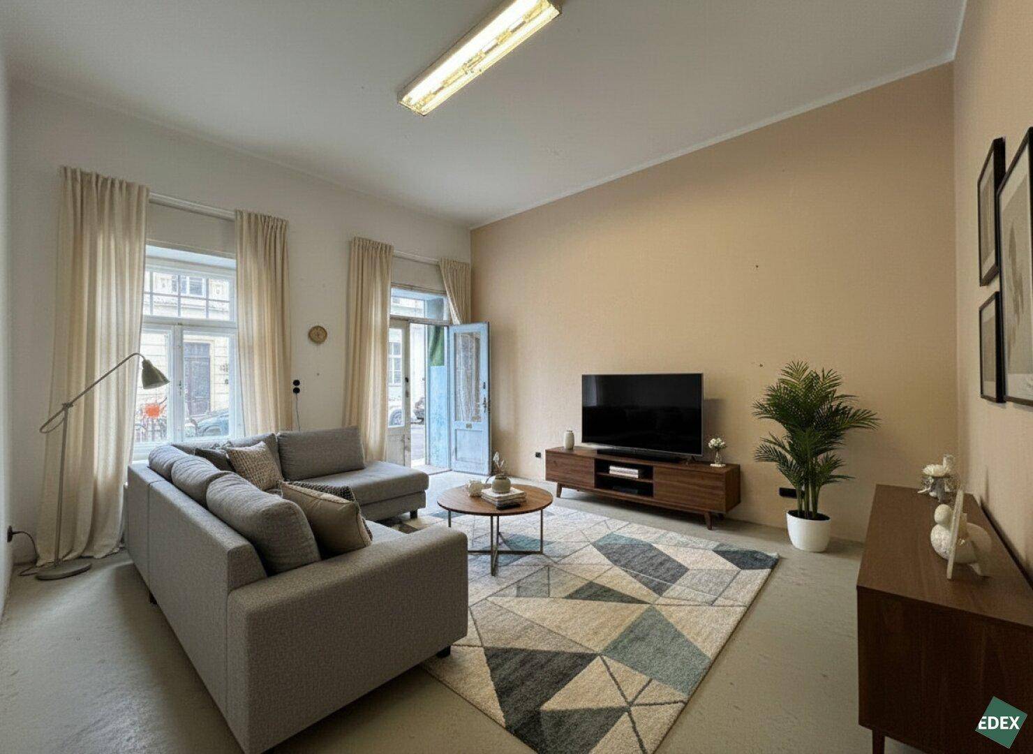 Gemütliches Wohnzimmer mit Sofa, Fernseher und Zugang zu einem französischen Balkon.