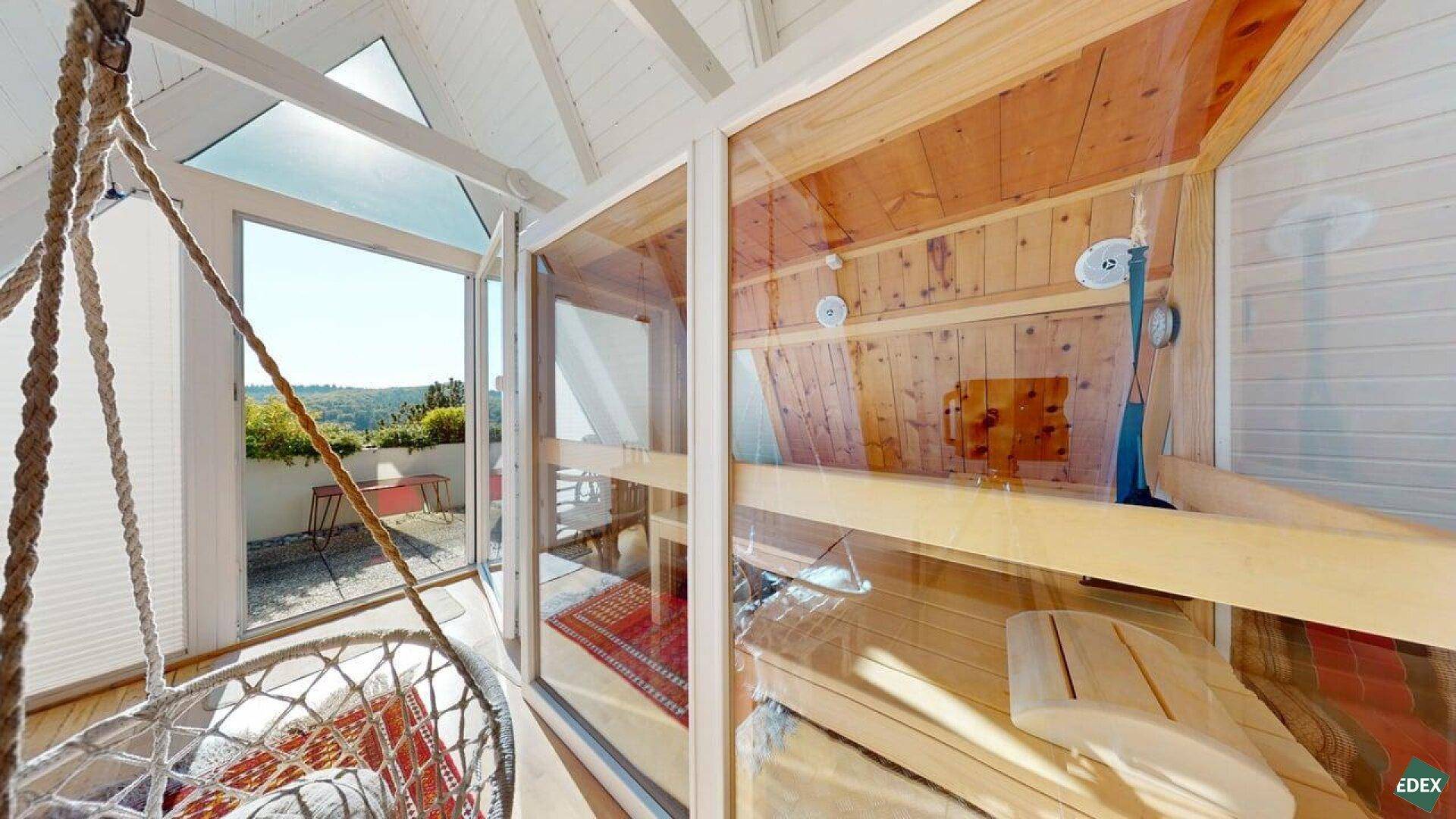 Heller Raum mit Sauna, Hängesessel und Zugang zu einer sonnigen Dachterrasse.