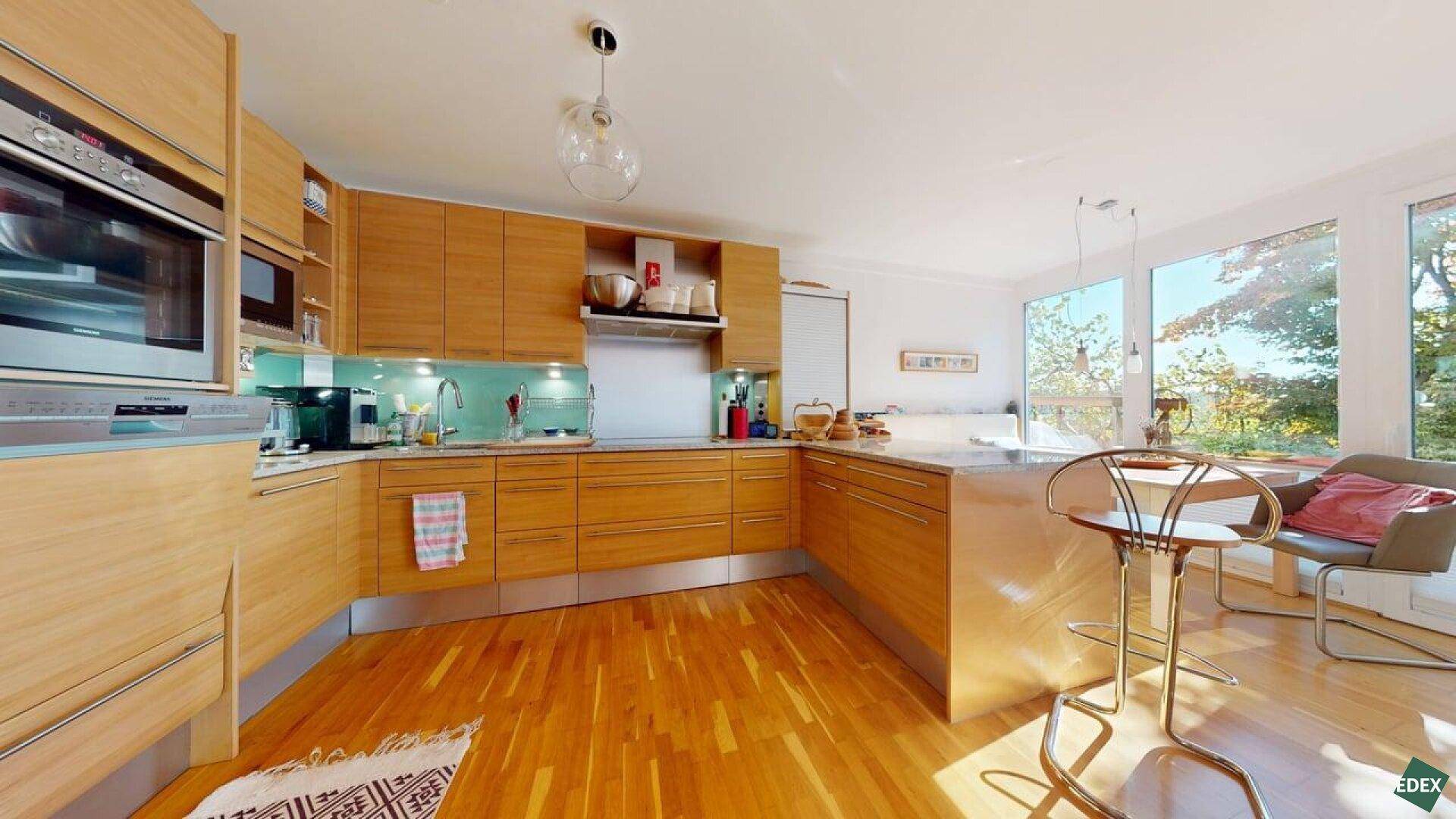 Moderne Holzküche mit integrierten Geräten, viel Arbeitsfläche und hellem Holzboden.