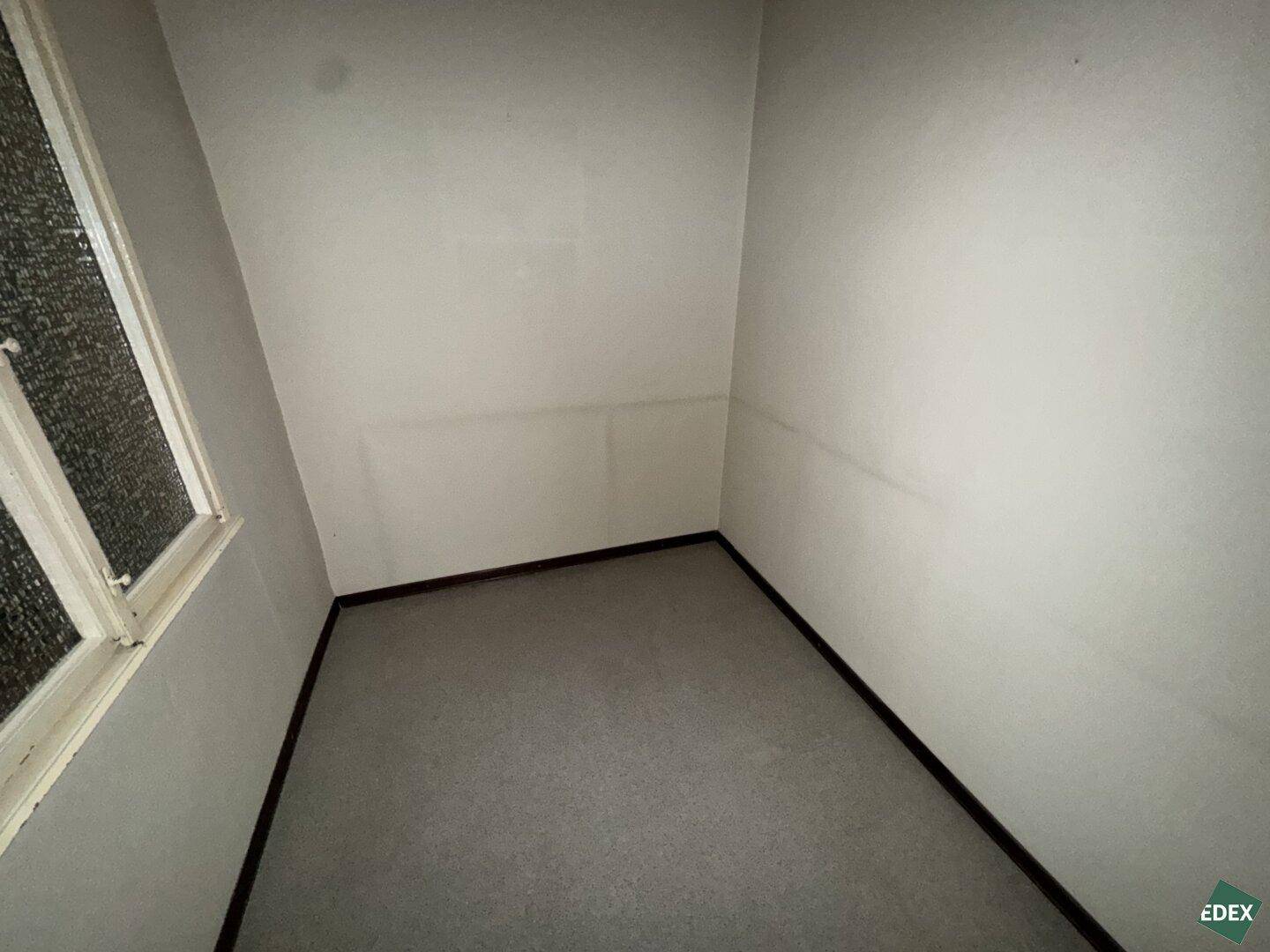Kleiner Raum mit Fenster und hellem Boden, vielseitig nutzbar als Abstellraum oder Büro.