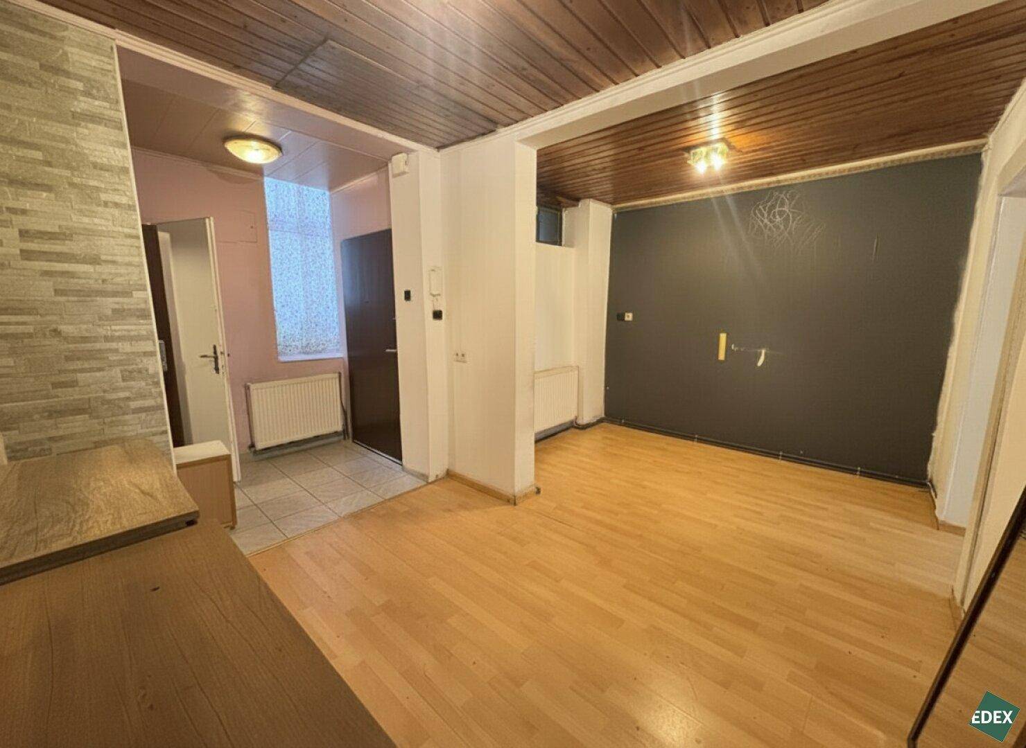 Flur mit Holzbalkendecke, Parkettboden und Zugang zu weiteren Räumen im Altbau.