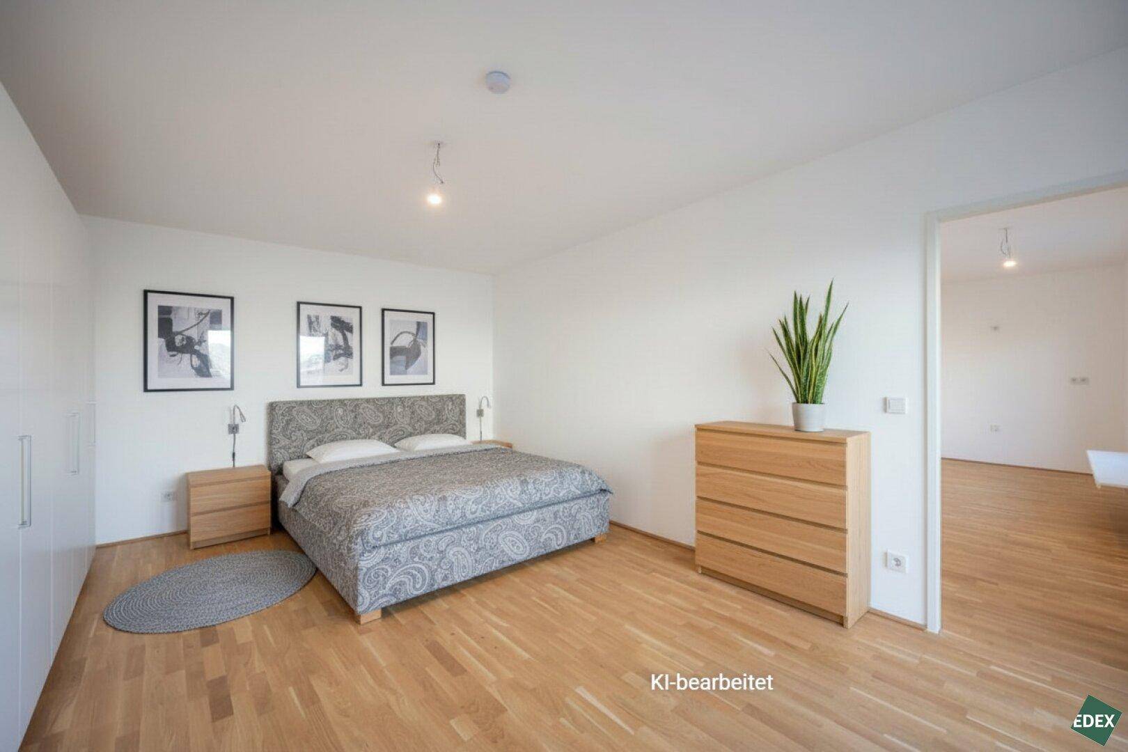 Geräumiges Schlafzimmer mit hellem Parkettboden, Doppelbett und schlichten Möbeln.