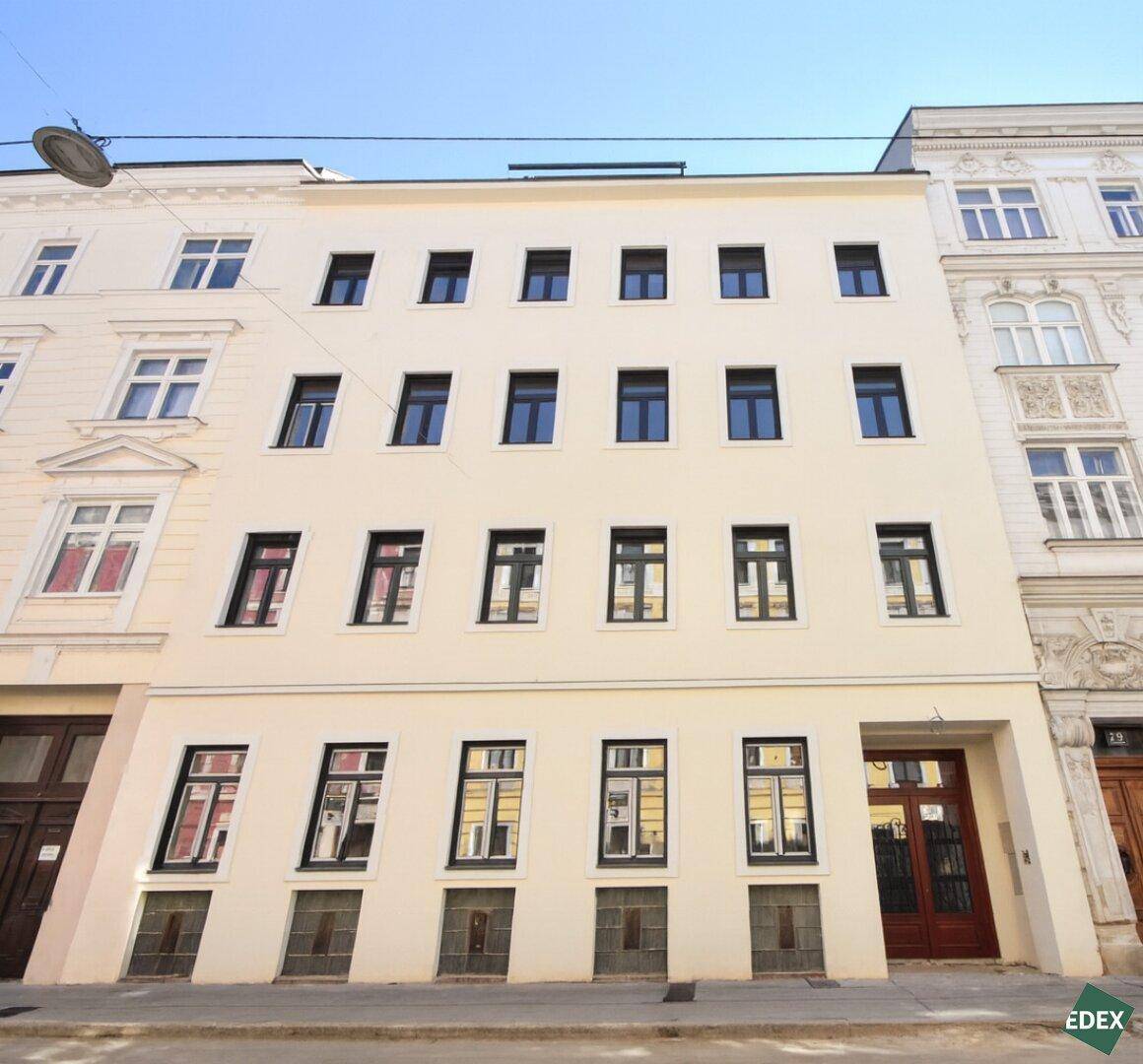 Die moderne Fassade des Gebäudes mit zahlreichen Fenstern und klaren Linien in urbaner Umgebung.