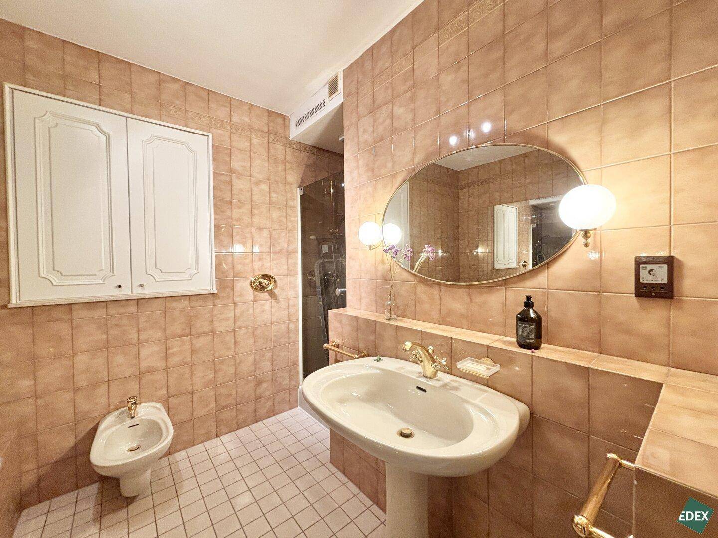 Detailansicht des Badezimmers mit Waschtisch, Bidet und passenden Armaturen im Retro-Stil.