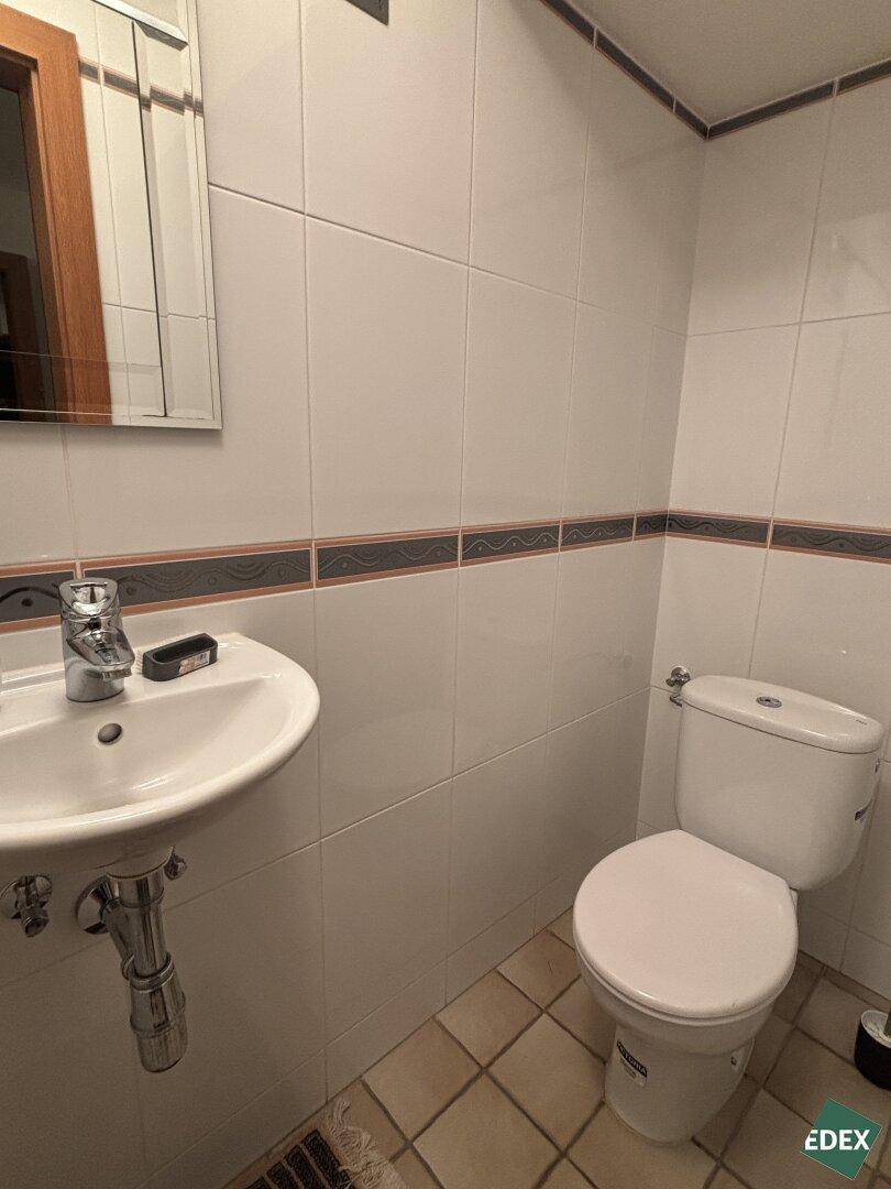 Kleines Gäste-WC mit Toilette, Waschbecken und Spiegelschrank.