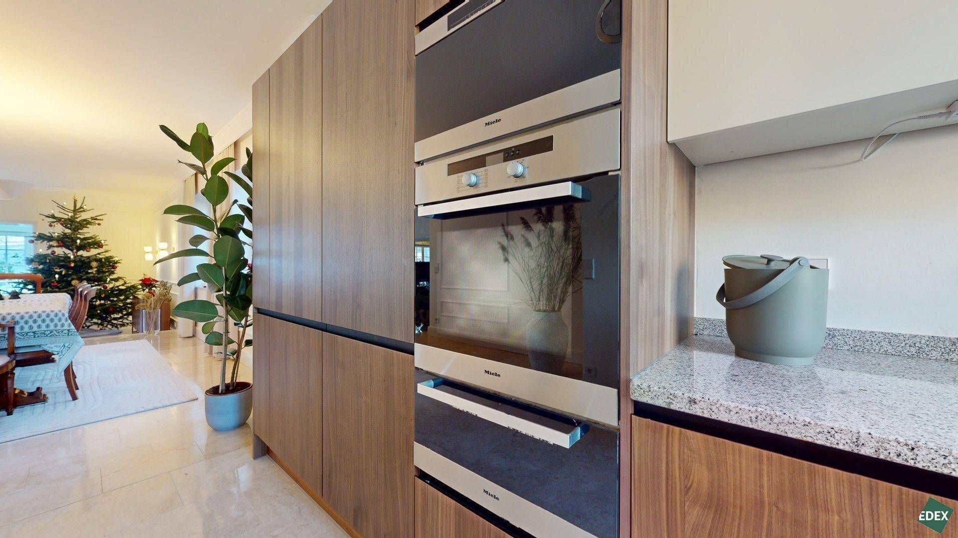 Hochwertige Einbaugeräte von Miele, darunter Backofen und Mikrowelle, in der modernen Küche.